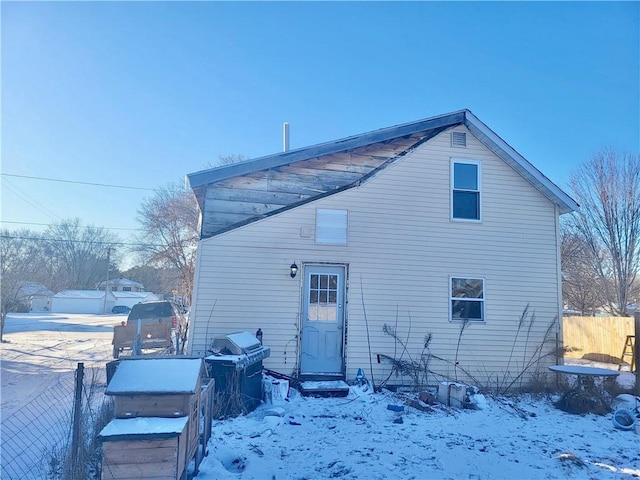 view of snow covered back of property