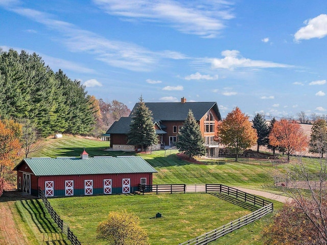 view of front of house featuring a rural view, a front yard, and an outdoor structure