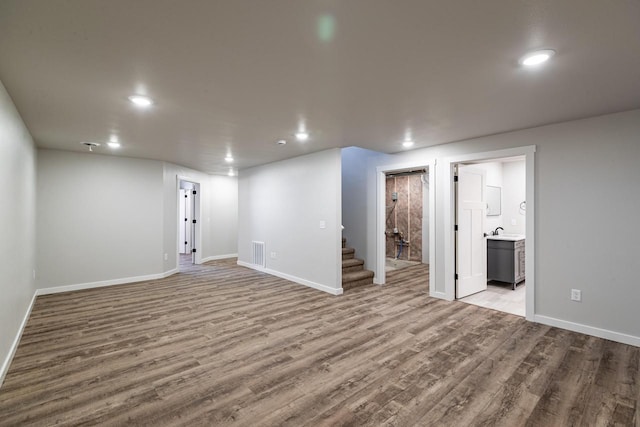 basement with sink and light hardwood / wood-style flooring