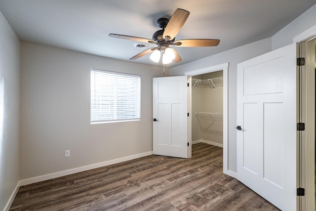 unfurnished bedroom featuring ceiling fan, a closet, and dark hardwood / wood-style flooring