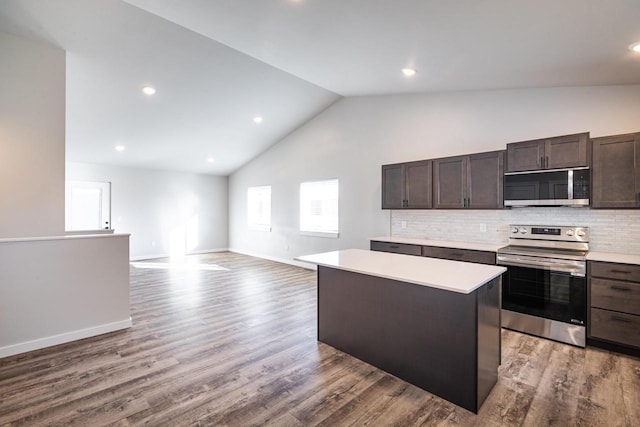 kitchen featuring a center island, hardwood / wood-style floors, appliances with stainless steel finishes, tasteful backsplash, and dark brown cabinetry