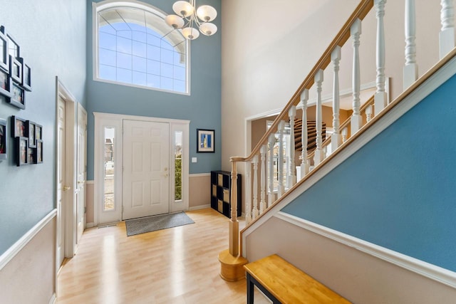 entryway featuring a notable chandelier, a high ceiling, and light hardwood / wood-style floors