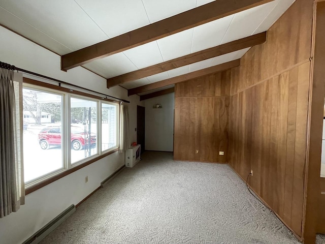 carpeted empty room featuring wooden walls, a baseboard radiator, and lofted ceiling with beams