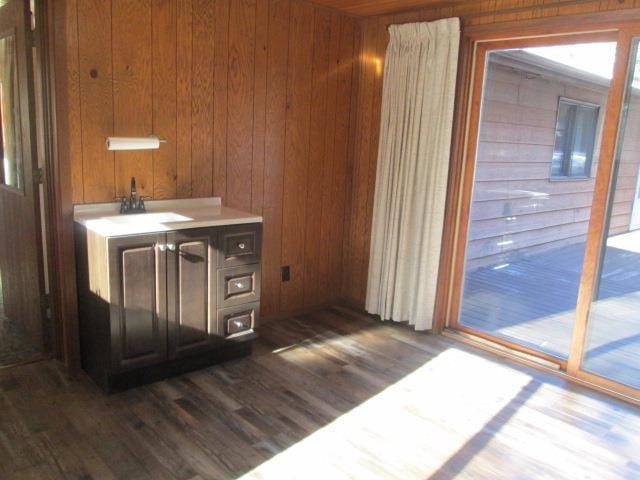 bar with wooden walls, dark hardwood / wood-style flooring, and sink