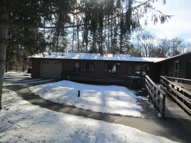 snow covered back of property with a garage