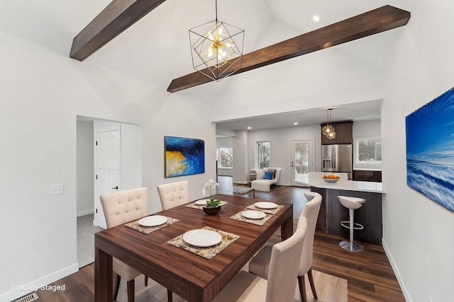 dining space with high vaulted ceiling, dark hardwood / wood-style flooring, and a chandelier