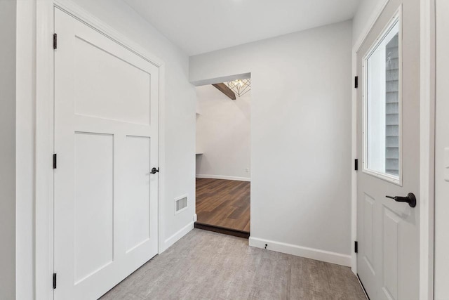 hallway with light hardwood / wood-style floors