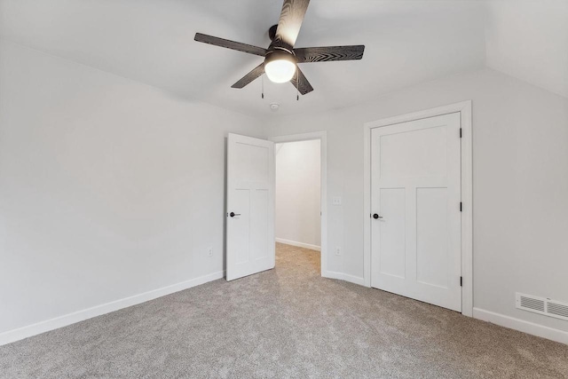 unfurnished bedroom featuring ceiling fan, lofted ceiling, and light carpet