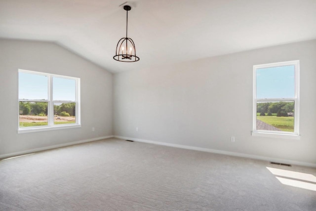 empty room with visible vents, baseboards, light carpet, lofted ceiling, and an inviting chandelier