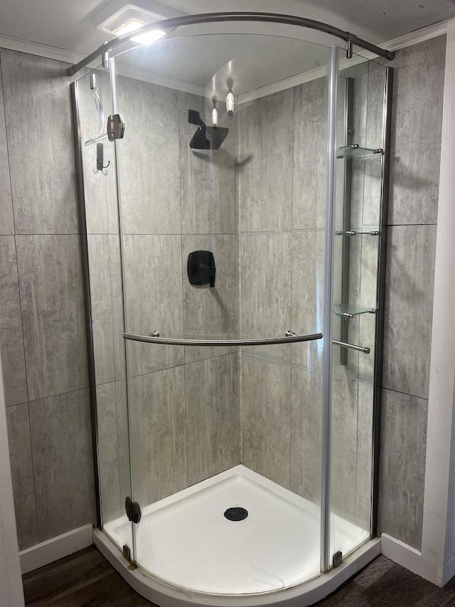 bathroom with walk in shower, ornamental molding, and hardwood / wood-style flooring