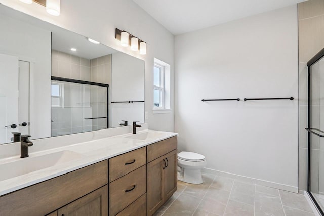 6635 Royal View Dr, Deforest, WI 53532 - bathroom featuring tiled shower, toilet, double vanity, and baseboards