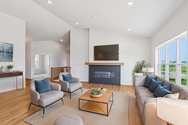 6635 Royal View Dr, Deforest, WI 53532 - living room with healthy amount of natural light, wood finished floors, high vaulted ceiling, a glass covered fireplace, and recessed lighting