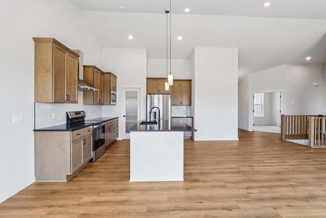 6635 Royal View Dr, Deforest, WI 53532 - kitchen featuring stainless steel appliances, dark countertops, a center island with sink, decorative backsplash, and lofted ceiling