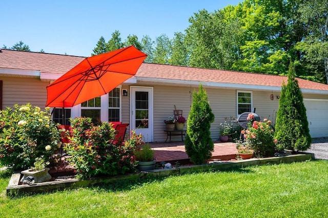 back of property featuring a lawn and a garage