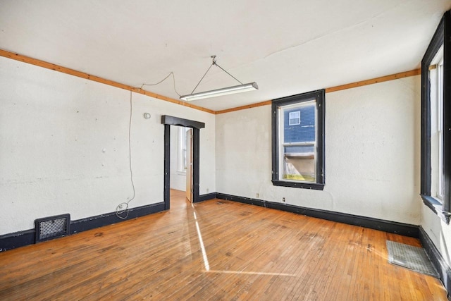 spare room featuring hardwood / wood-style flooring and ornamental molding