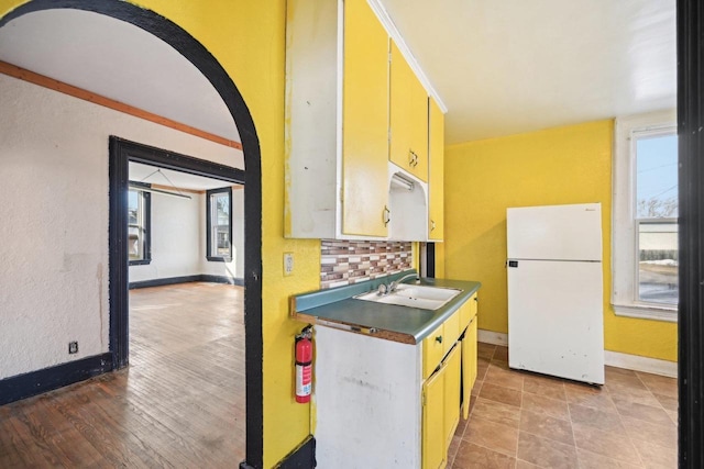 kitchen featuring sink, crown molding, decorative backsplash, and white fridge