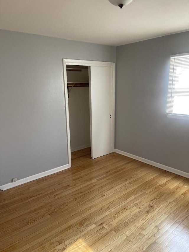 unfurnished bedroom featuring light hardwood / wood-style flooring and a closet