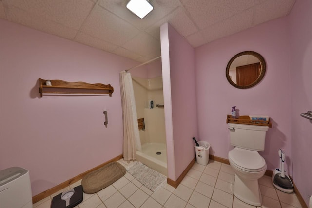 bathroom featuring curtained shower, a paneled ceiling, toilet, and tile patterned flooring