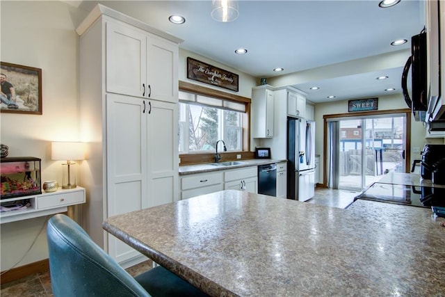 kitchen featuring sink, white cabinets, a kitchen bar, and appliances with stainless steel finishes