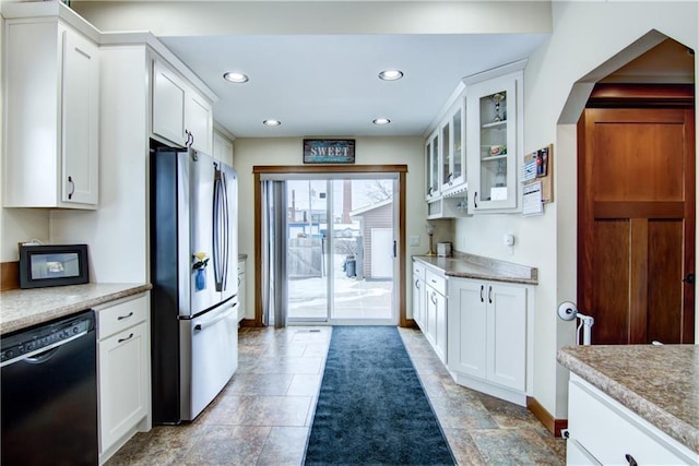 kitchen featuring white cabinetry, black dishwasher, and stainless steel refrigerator