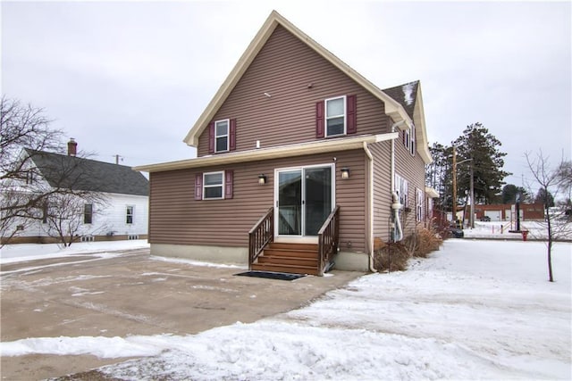 view of snow covered rear of property