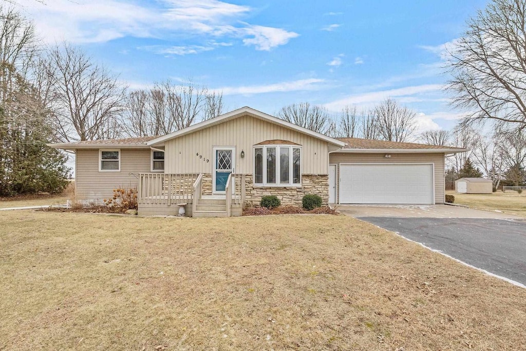 single story home featuring a garage and a front lawn