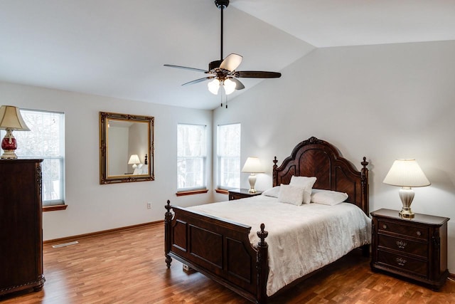 bedroom featuring hardwood / wood-style flooring, ceiling fan, lofted ceiling, and multiple windows