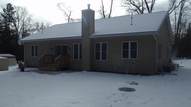 snow covered house with central AC