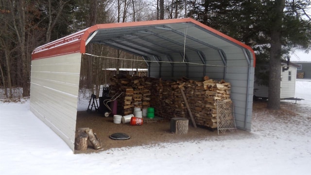 snow covered structure featuring a carport