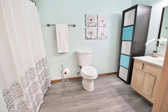 bathroom featuring vanity, wood-type flooring, and toilet