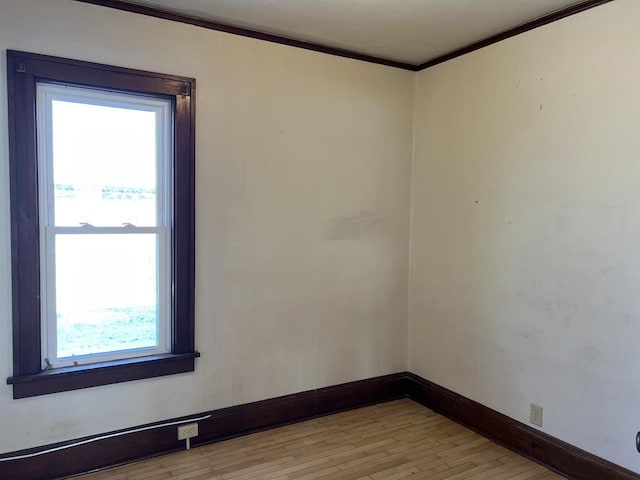 unfurnished room featuring a healthy amount of sunlight, light hardwood / wood-style flooring, and ornamental molding