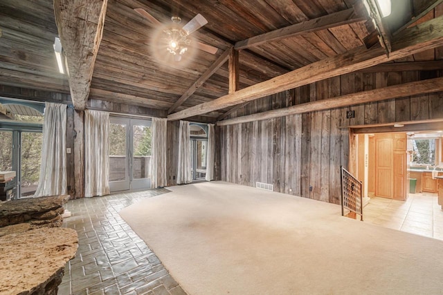 miscellaneous room featuring wood walls, beam ceiling, high vaulted ceiling, and french doors