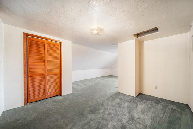 bonus room featuring dark carpet, a textured ceiling, and vaulted ceiling