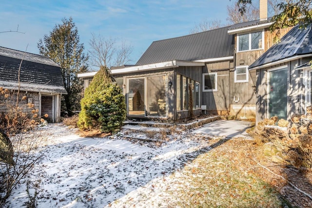 view of snow covered rear of property