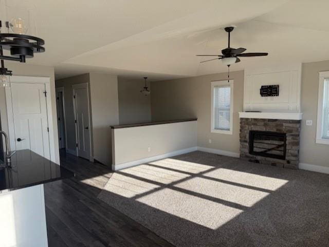 unfurnished living room featuring vaulted ceiling, dark hardwood / wood-style floors, and a fireplace