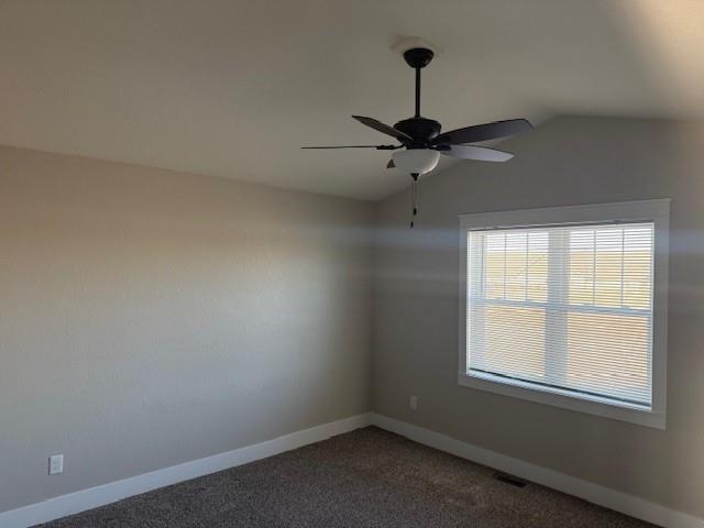 carpeted empty room featuring vaulted ceiling and ceiling fan