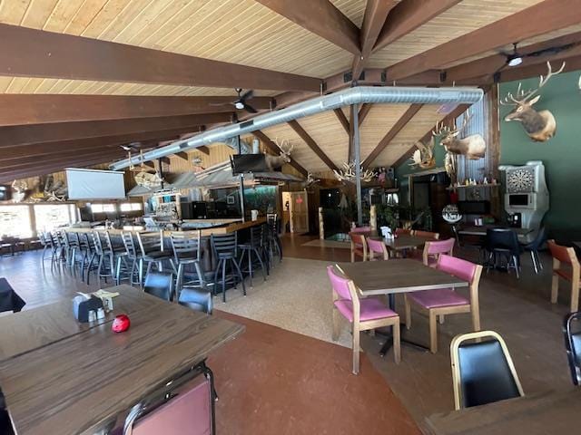 dining area featuring ceiling fan, lofted ceiling with beams, and wooden ceiling