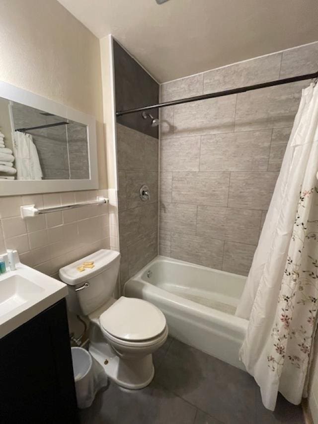 full bathroom featuring tile walls, tile patterned flooring, vanity, toilet, and shower / bath combo with shower curtain