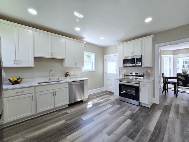 kitchen with sink, white cabinets, dark hardwood / wood-style floors, and appliances with stainless steel finishes