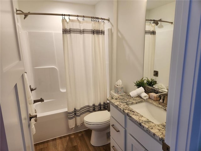 full bathroom featuring hardwood / wood-style flooring, toilet, shower / tub combo, and vanity