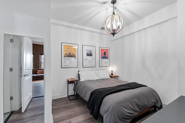 bedroom featuring dark wood-type flooring and a notable chandelier