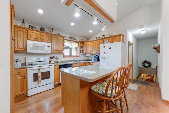 kitchen with white appliances, vaulted ceiling, light hardwood / wood-style flooring, and a kitchen island