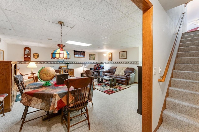 dining area with a drop ceiling and carpet flooring