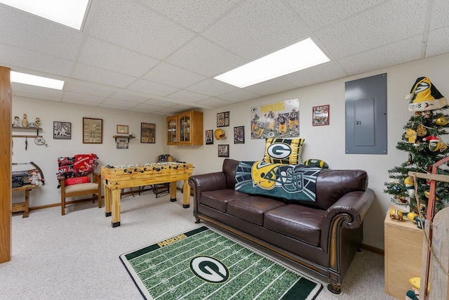 carpeted living room with electric panel and a drop ceiling