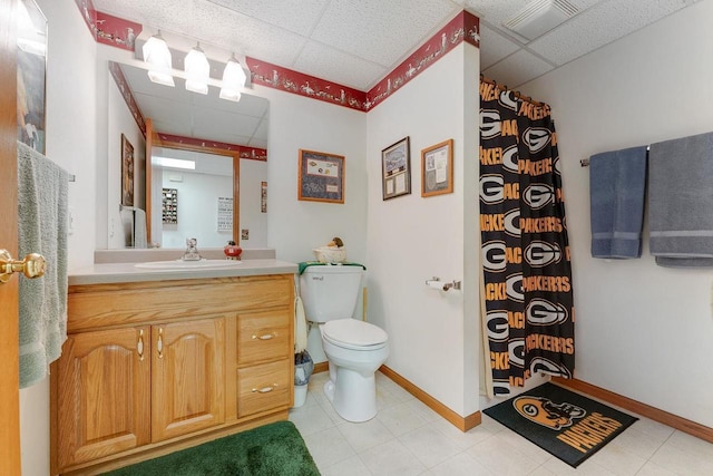 bathroom with toilet, a paneled ceiling, and vanity