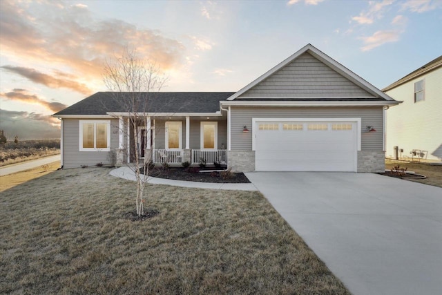 view of front of home featuring a porch, a garage, and a lawn