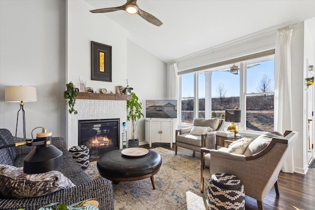 living room with ceiling fan, a fireplace, dark hardwood / wood-style floors, and vaulted ceiling