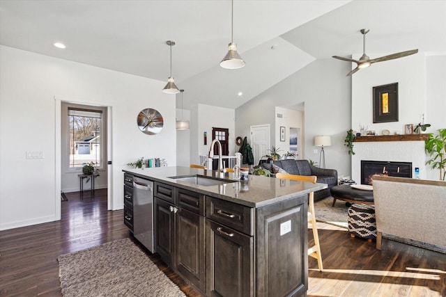 kitchen featuring sink, dark hardwood / wood-style floors, an island with sink, decorative light fixtures, and stainless steel dishwasher