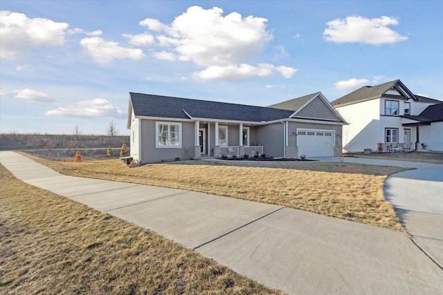 view of front of home with a garage, a front lawn, and covered porch