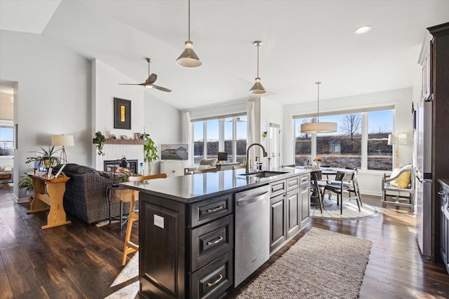 kitchen featuring sink, dark wood-type flooring, dishwasher, a kitchen island with sink, and vaulted ceiling